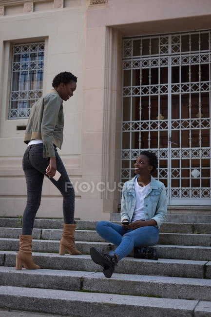 Gemelli fratelli che interagiscono tra loro sui gradini della città — Foto stock
