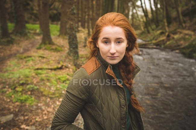 Portrait of young female hiker standing near the river coast — Stock Photo