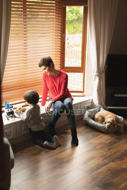 Mutter und Sohn spielen zu Hause im Wohnzimmer — Stockfoto