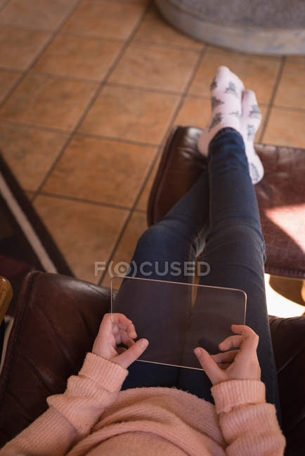 Girl using glass digital tablet in living room at home — Stock Photo