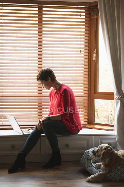 Женщина с ноутбуком в гостиной на дому — стоковое фото
