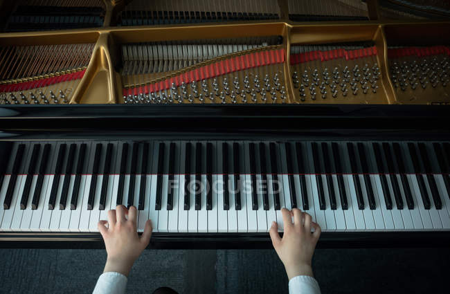Overhead view of schoolgirl playing piano in music school — Stock Photo