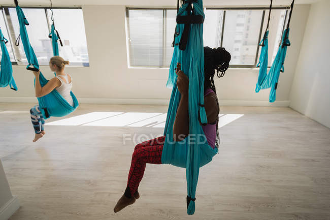 Deux femmes se relaxent dans un hamac balançoire au studio de fitness — Photo de stock