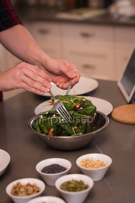 Donna che prepara insalata in cucina a casa — Foto stock