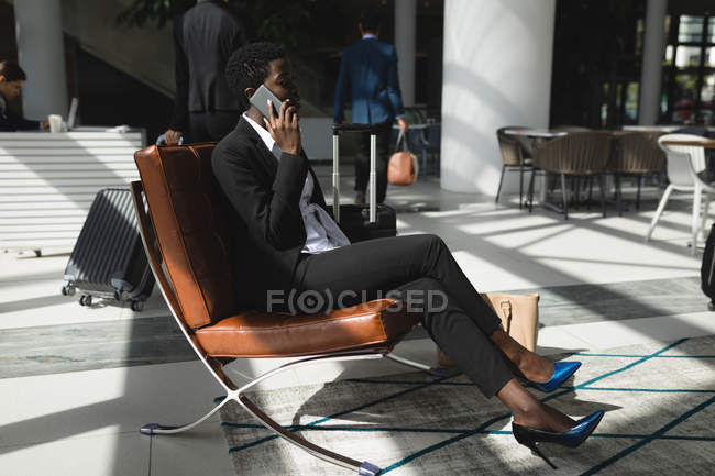 Femme d'affaires concentrée parlant au téléphone au bureau — Photo de stock