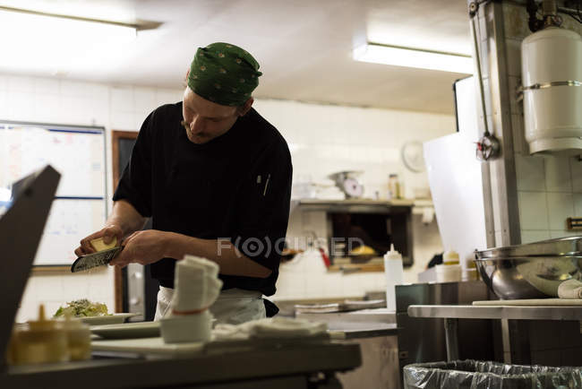 Chef masculin servant de la nourriture dans une assiette au restaurant — Photo de stock