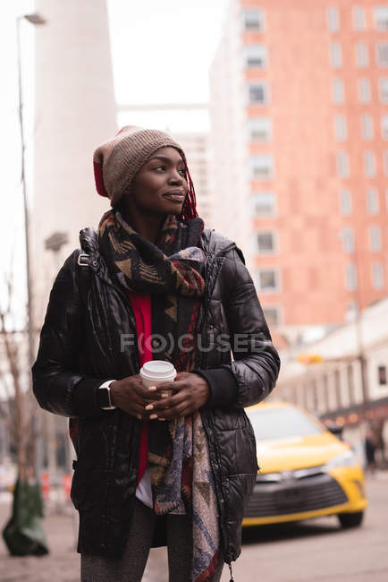 Mulher atenciosa tomando café na rua da cidade — Fotografia de Stock