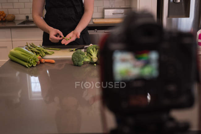 Mulher preparando legumes na cozinha em casa — Fotografia de Stock