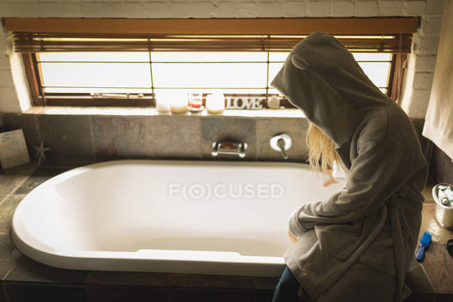 Ragazza seduta sulla vasca da bagno a casa — Foto stock