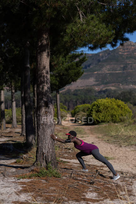 Athlète féminine déterminée faisant de l'exercice dans la forêt — Photo de stock