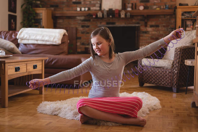 Menina brincando com a primavera na sala de estar em casa — Fotografia de Stock