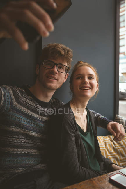 Jeune couple prenant un selfie dans le café — Photo de stock