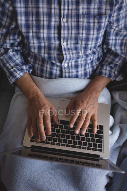 Homme âgé de la section moyenne utilisant un ordinateur portable à la maison — Photo de stock