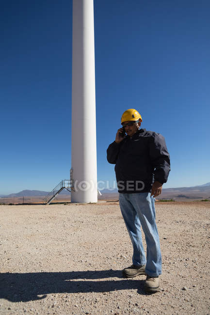 Engineer talking on mobile phone at wind farm — Stock Photo