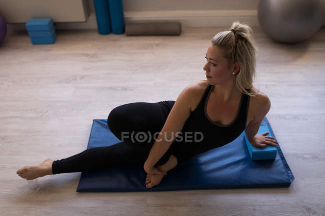 Женщина выполняет упражнения на растяжку в фитнес-студии — стоковое фото
