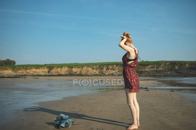 Frau spielt an einem sonnigen Tag mit ihrem Schatten am Strand — Stockfoto
