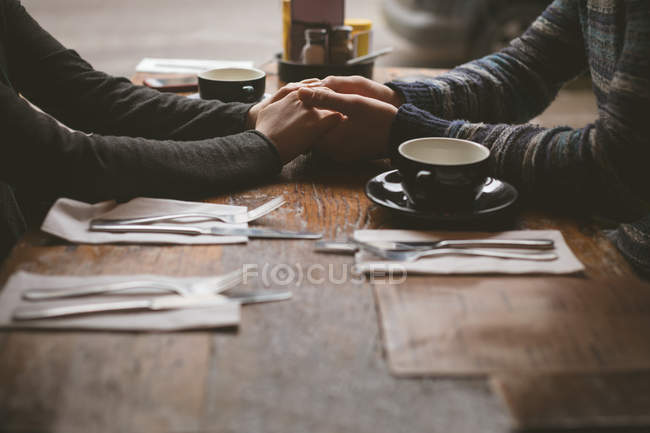 Романтическая пара, держащаяся за руки в кафе — стоковое фото
