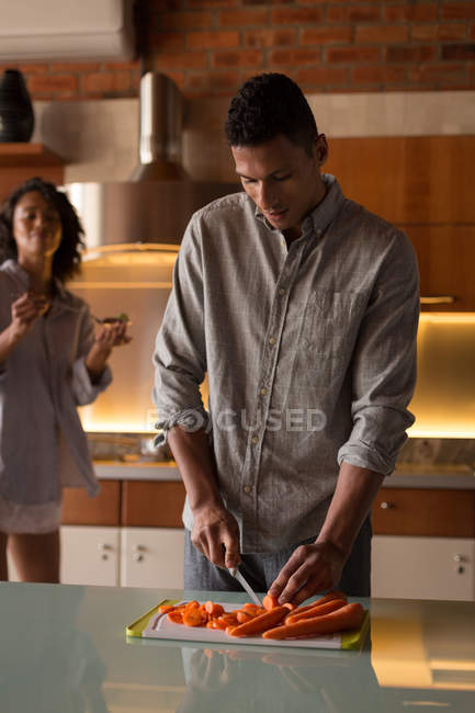 Man cutting veegatbes in the kitchen a home — Stock Photo