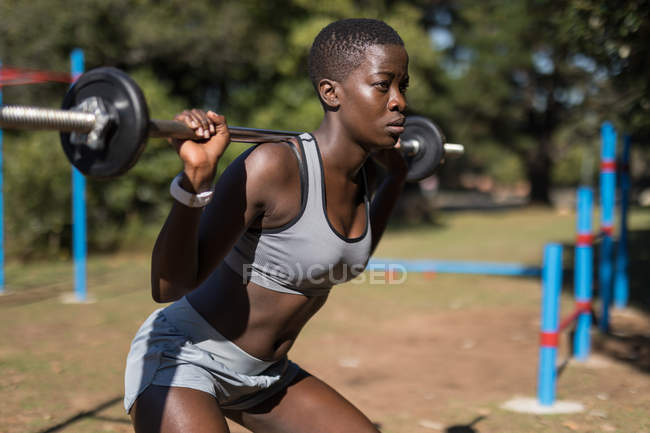 Determined female athlete lifting barbell — Stock Photo
