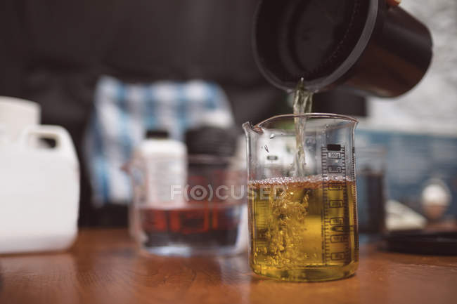 Женщина-фотограф наливает химикат во фляжку на фотостудию — стоковое фото