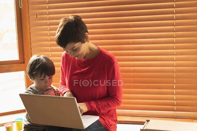 Мати і син сидять з ноутбуком вдома — стокове фото