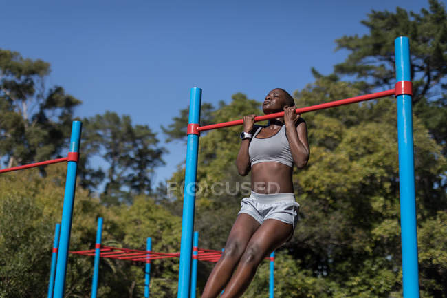 Entschlossene Athletin trainiert am Stufenbarren — Stockfoto
