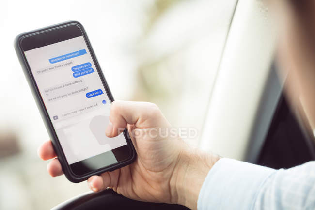 Close-up of businessman using mobile phone in a car — Stock Photo