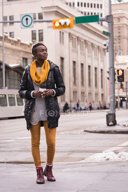 Thoughtful woman having coffee in city street — Stock Photo