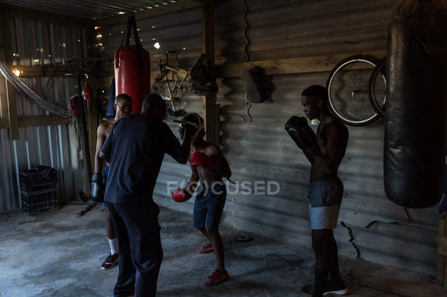 Treinador masculino treinando seus alunos em estúdio de fitness — Fotografia de Stock