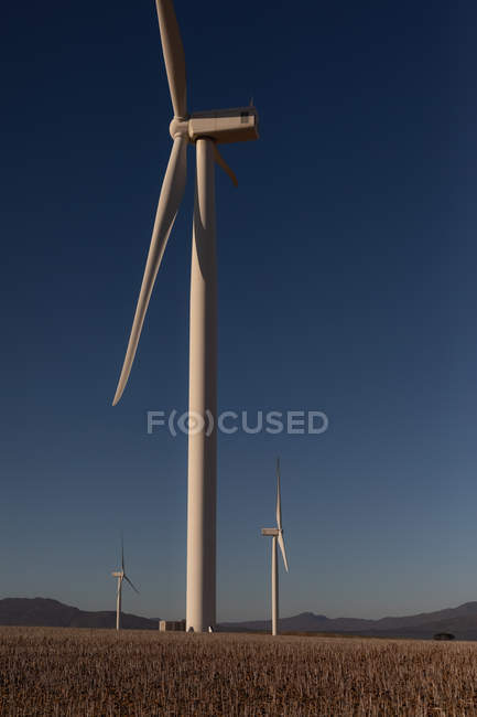 Molino de viento en un parque eólico durante el día - foto de stock