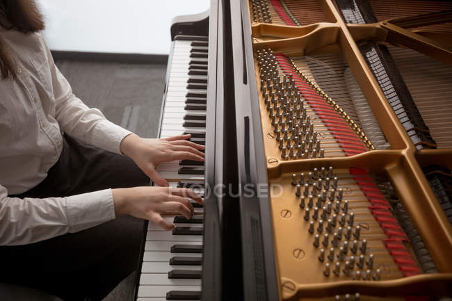 Parte média da aluna tocando piano na escola de música — Fotografia de Stock