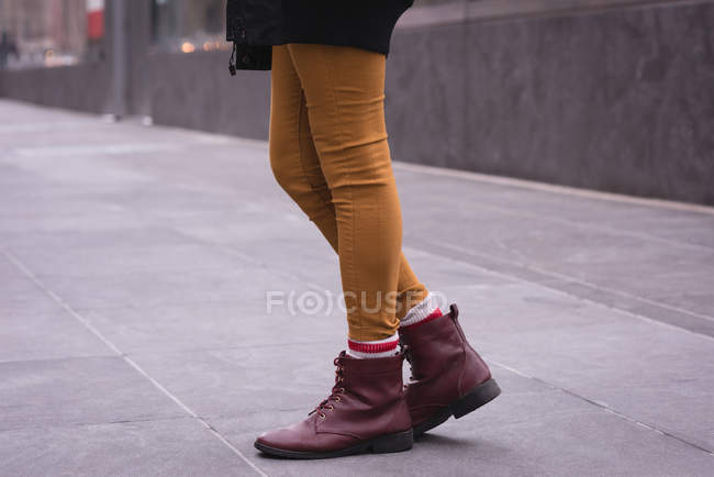Низька частина жінки, що стоїть на міській вулиці — стокове фото