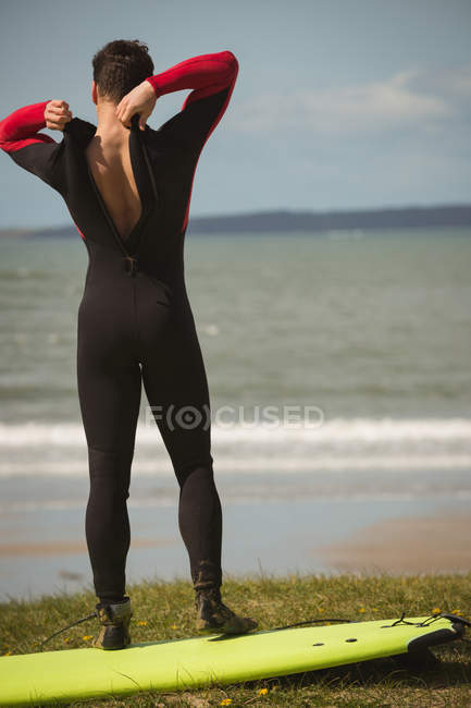 Vista trasera del surfista con tabla de surf preparándose para el surf - foto de stock