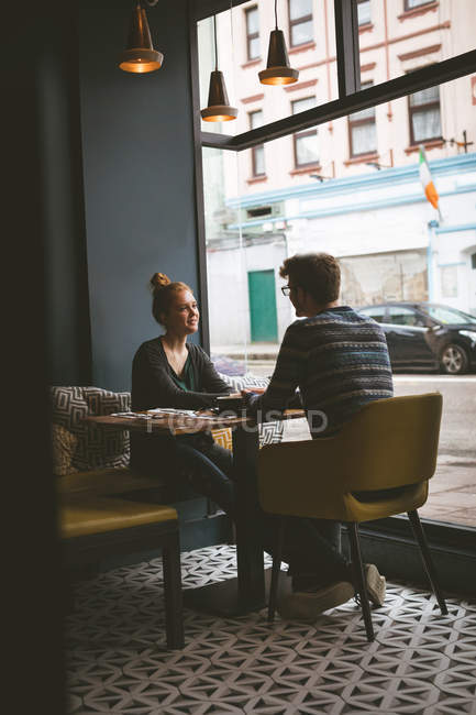 Молода пара розмовляє один з одним в кафе — стокове фото