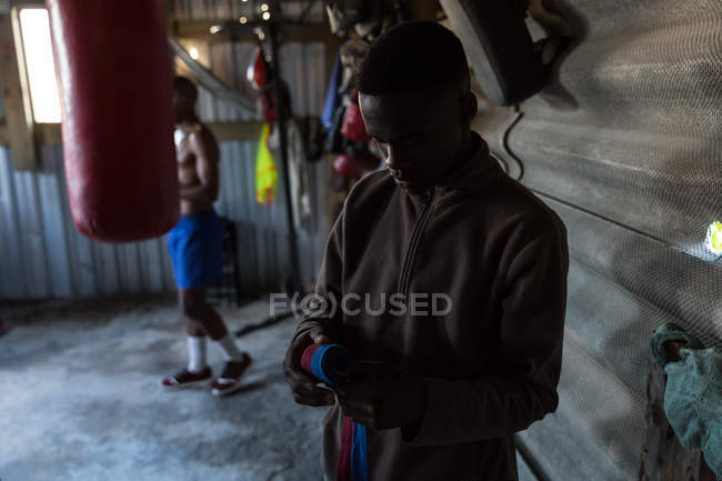 Чоловічий боксер зав'язує ручне обгортання на фітнес-студії — стокове фото