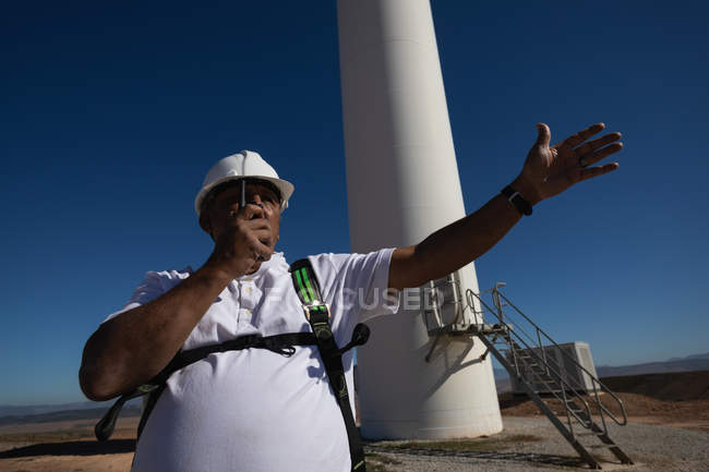 Engineer talking on a walkie talkie at a wind farm — Stock Photo