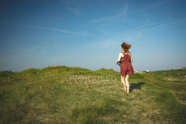 Задний вид женщины, бегущей по холму — стоковое фото