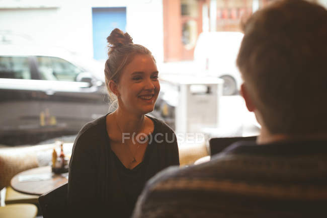 Femme souriante parlant à l'homme dans le café — Photo de stock