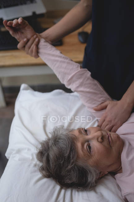 Primer plano del fisioterapeuta dando un masaje de mano a la mujer mayor - foto de stock