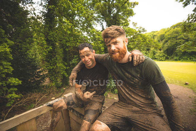 Ajuste homens relaxando sobre curso de obstáculo no acampamento de inicialização — Fotografia de Stock