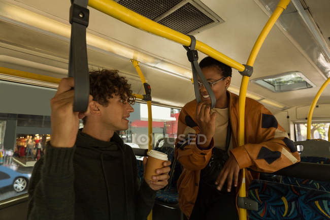 Homem e mulher interagindo entre si enquanto viajam no ônibus — Fotografia de Stock