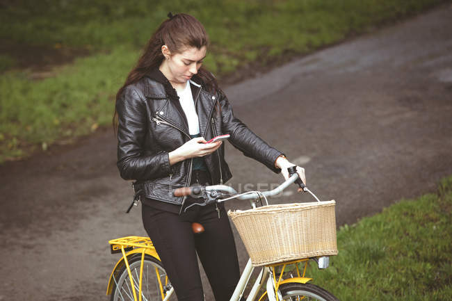 Красива жінка на велосипеді за допомогою мобільного телефону — стокове фото