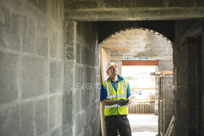 Engineer looking at the doorway at construction site — Stock Photo