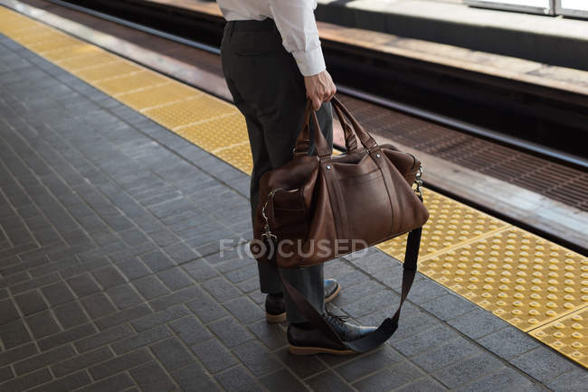 Section basse de l'homme attendant le train à la gare — Photo de stock
