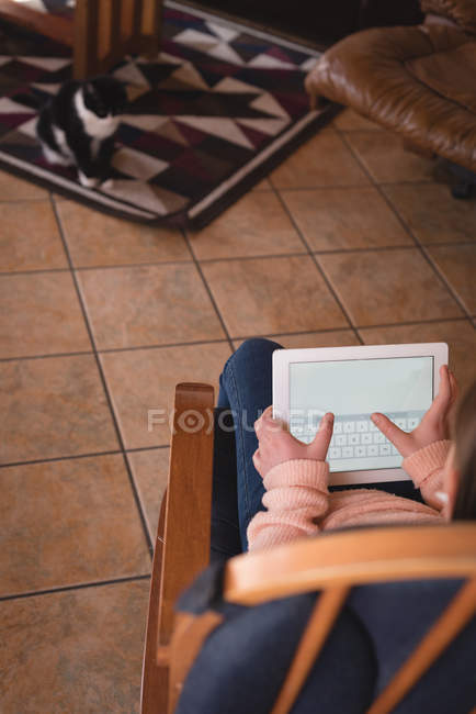 Дівчина, використовуючи цифровий планшетний у вітальні на дому — стокове фото