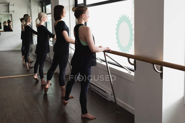 Group of women standing holding the barre at the gym — Stock Photo