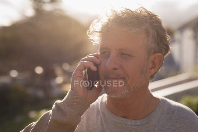 Gros plan d'un aîné parlant sur son téléphone portable — Photo de stock