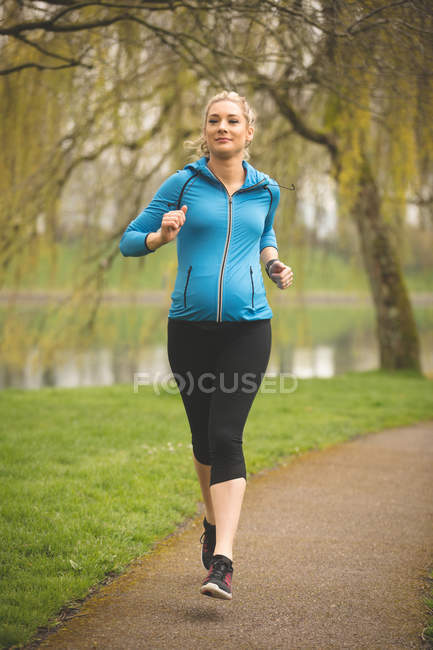 Belle femme enceinte jogging dans le parc — Photo de stock