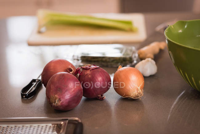 Cebolas em uma bancada na cozinha em casa — Fotografia de Stock