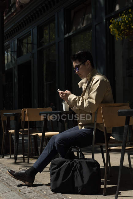 Молодой человек использует мобильный телефон в солнечный день — стоковое фото